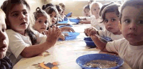 Foto de várias crianças fazendo uma refeição