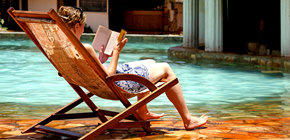 Foto de uma mulher lendo sentada sob o sol